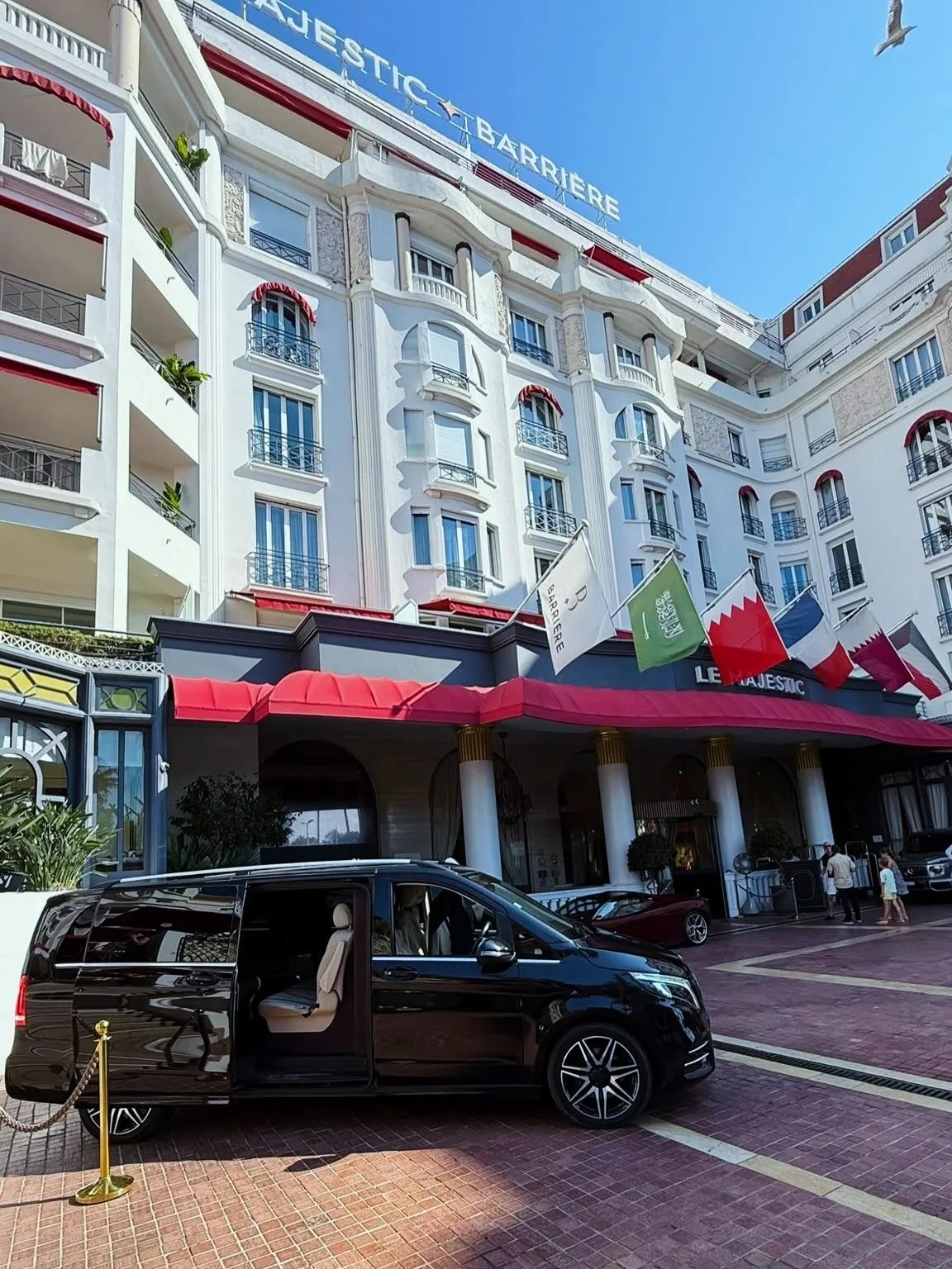 Black Mercedes V-Class with its sliding door open outside the Hôtel Barrière Le Majestic in Cannes